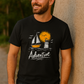 Black Adventure t-shirt with hand-drawn sailboat lighthouse and golden sun nautical design