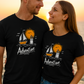Black Adventure t-shirt with hand-drawn sailboat lighthouse and golden sun nautical design