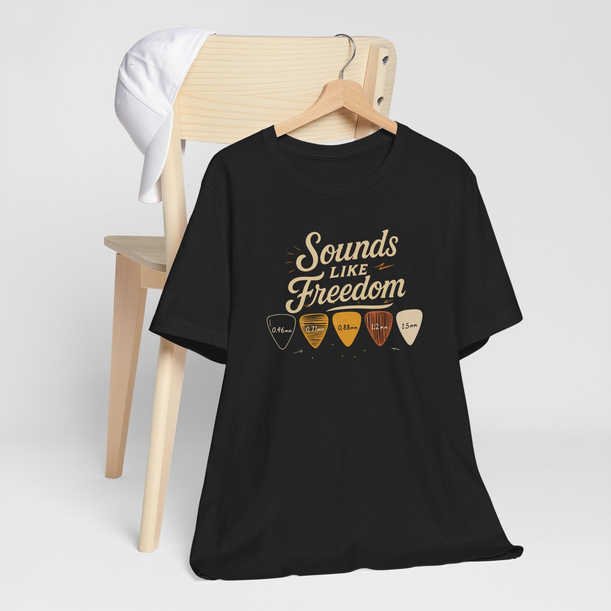 Black Sounds Like Freedom t-shirt with authentic guitar pick design and thickness measurements