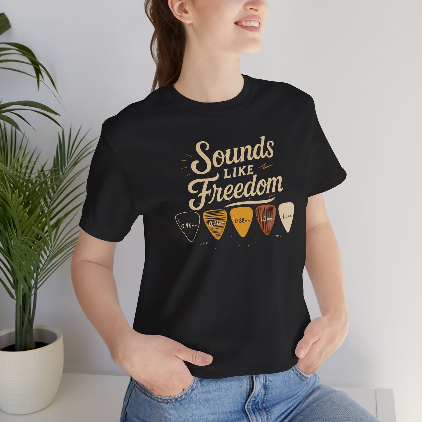 Black Sounds Like Freedom t-shirt with authentic guitar pick design and thickness measurements