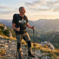 Man hiking on a mountain trail with a scenic view in the background